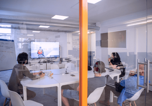 A team in a meeting room watching a presentation on a large screen