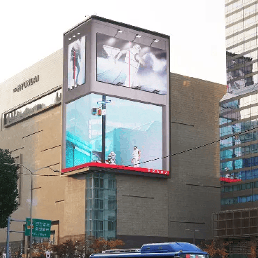 A large outdoor 3D billboard displaying the Prada Linea Rossa Fall/Winter 2022 campaign in an urban setting